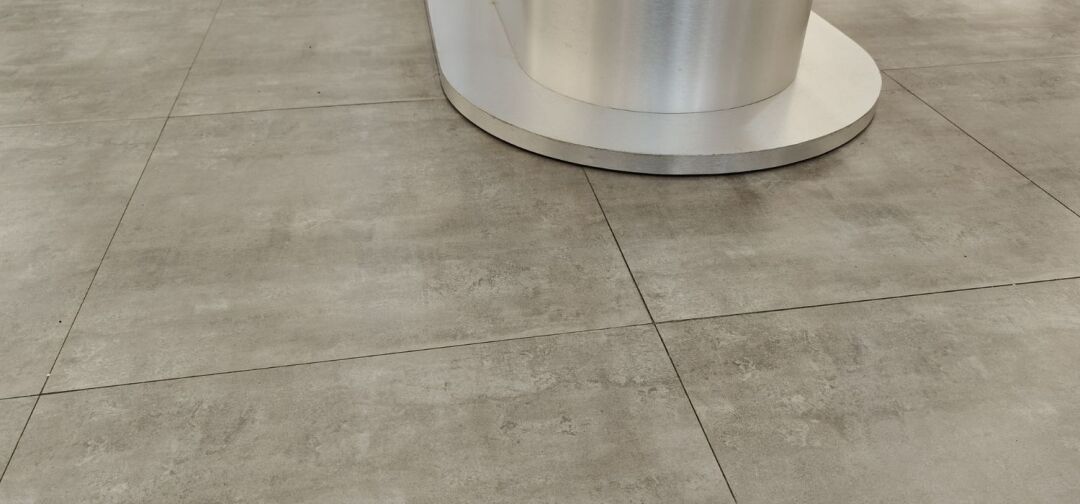 Smooth commercial concrete floor with clean control joints and a modern finish surrounding a circular column base.